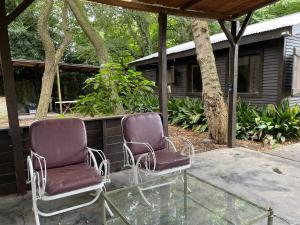 two chairs sitting on a patio in front of a house at Cabaña - El Bamboo Eventos in Arturo SeguÃ­