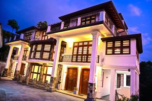 a large white house with its lights on at Windsor in Kandy