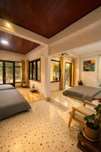 a bedroom with two beds and a table and windows at Umee Stayin Đà Lạt in Da Thanh +22 photos