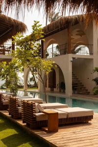 a resort with lounge chairs and a swimming pool at Neem - Boutique Hotel Madiha - ADULTS ONLY in Kamburugamuwa