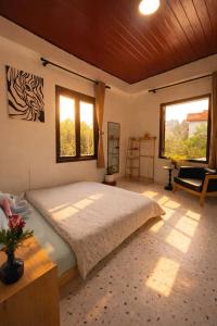 a bedroom with a large bed and two windows at Umee Stayin Đà Lạt in Da Thanh