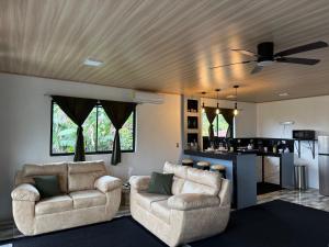 a living room with two chairs and a ceiling fan at Arenal cautiva in El Castillo de La Fortuna