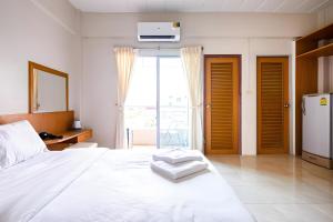 a bedroom with a white bed and a large window at GO INN Suvarnabhumi Airport โก อินน์ สนามบินสุวรรณภูมิ in Lat Krabang