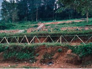 a dirt field with a fence on the side of it at Hilltop camping vanjangi in Pāderu