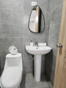 a bathroom with a toilet and a sink and a mirror at Amazing Three Bedrooms House in La Romana