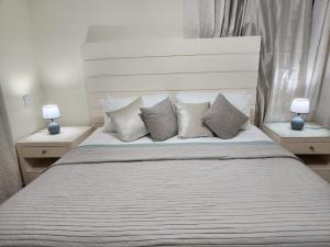 a bedroom with a bed with pillows and two lamps at Amazing Three Bedrooms House in La Romana +5 photos