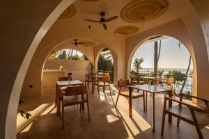 a restaurant with arches and tables and chairs at Neem - Boutique Hotel Madiha - ADULTS ONLY in Kamburugamuwa