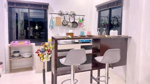 a kitchen with a counter and two stools in it at Abbas House by Swiss Chalet, 2-room Cottages in Krabi