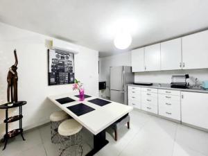 a white kitchen with a table and a refrigerator at Departamento Getsemani in Hermosillo
