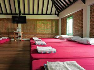 a large room with a large bed with pink sheets at Omahe Kancaku in Balong +76 photos