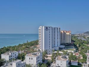 a tall white building next to the ocean at Doubletree By Hilton Sanya Bay in Sanya