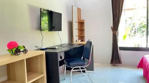 a room with a desk with a monitor and a chair at Abbas House by Swiss Chalet, 2-room Cottages in Krabi