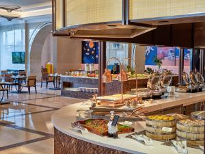 a buffet line with food on display in a restaurant at Doubletree By Hilton Sanya Bay in Sanya