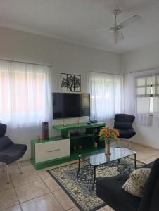 a living room with a tv and a couch and a table at Cantinho da vovó Sol in Cabo Frio
