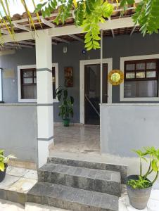 a house with a staircase leading to the front door at Cantinho da vovó Sol in Cabo Frio