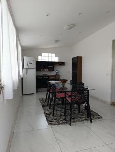 a kitchen with a table and chairs and a refrigerator at Cantinho da vovó Sol in Cabo Frio