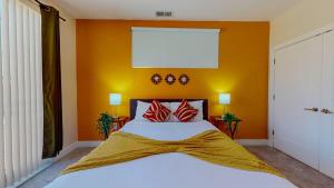 a bedroom with orange walls and a bed with red pillows at Stylish Home and Cozy200 in Stamford