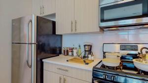 a kitchen with a stainless steel refrigerator and a stove at Stylish Home and Cozy200 in Stamford