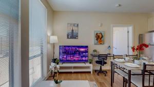 a living room with a television and a dining room at Stylish Home and Cozy200 in Stamford