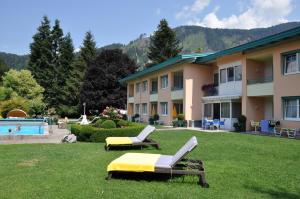 ein Gebäude mit einem Garten mit Liegestühlen und einem Pool in der Unterkunft Ferienapartments Birkenhof in Döbriach