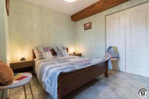 a bedroom with a bed and two chairs in it at Perets petit in Montégut-Lauragais