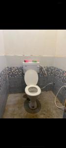 a bathroom with a white toilet in a room at Mishthi singh homestay in Jalālpur Dhai