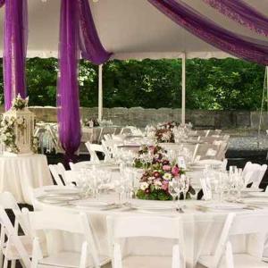 un grupo de mesas con sillas blancas y cortinas púrpuras en Dansereau House, en Thibodaux