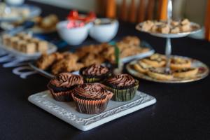a table topped with cupcakes and other desserts on plates at Arapawa Homestead in Picton
