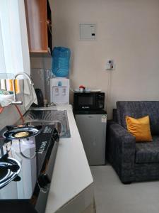 a kitchen with a stove top oven next to a couch at Machakos Town Studios in Machakos