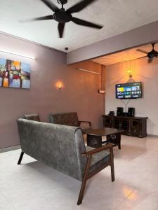 a living room with a couch and a tv at PRS Homestay in Chemor