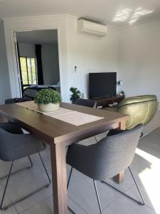 a wooden table with chairs and a potted plant on it at Stunning Cable Beach - Unit in Cable Beach
