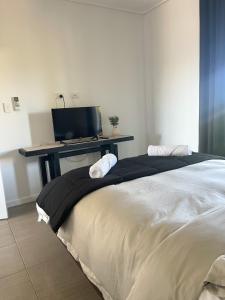 a bedroom with a bed and a desk with a tv at Stunning Cable Beach - Unit in Cable Beach +11 photos