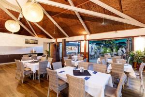 a dining room with white tables and chairs at Stunning Cable Beach - Unit in Cable Beach