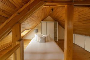 a attic bedroom with a bed with white pillows at Loft Chaleureux - Le Chalet Montois in Mons