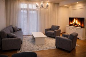 a living room with two chairs and a fireplace at Chill House in Kutaisi