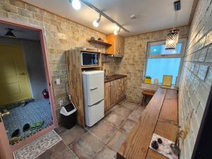a kitchen with a refrigerator and a window at Hundred Years Hanok in Mokpo