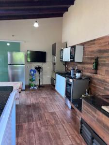 a large kitchen with wooden floors and a counter top at Chácara Tuler in Foz do Iguaçu