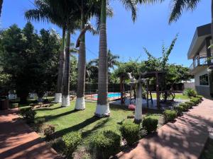a park with palm trees and a playground at Chácara Tuler in Foz do Iguaçu