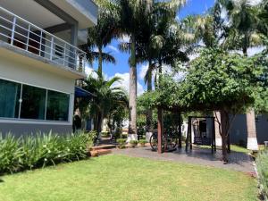 a house with palm trees and a gazebo at Chácara Tuler in Foz do Iguaçu