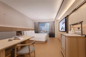 a hotel room with a bed and a desk at JI Hotel Nanjing Gulou Square in Nanjing