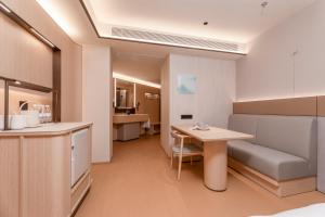 a room with a kitchen and a table and a couch at JI Hotel Nanjing Gulou Square in Nanjing