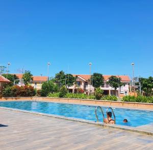 a woman is in a swimming pool at Casa Del Sol! 2BR Puerto Princesa in Puerto Princesa City