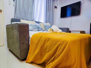 a dog sitting on a bed with a yellow blanket at Casa Del Sol! 2BR Puerto Princesa in Puerto Princesa City