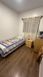 a bedroom with a bed and a wooden floor at Chalet Bilu in Piriápolis