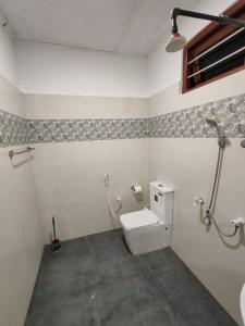 a bathroom with a toilet in a room at Bird Nest Homestay in Jaffna +2 photos