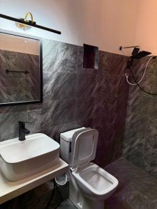a bathroom with a white toilet and a sink at Mount Boutique Villa in Kandy +4 photos