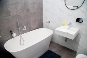 a bathroom with a white tub and a sink at Wangu Urban in Mpemba +27 photos