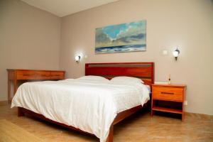 a bedroom with a large white bed and a nightstand at Wangu Urban in Mpemba