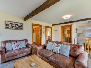 a living room with two leather couches and a table at Milking Parlour - Uk48911 in Allonby