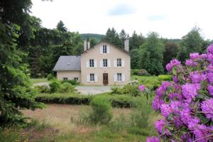 a house in the middle of a garden with purple flowers at Brenac in Eymoutiers
